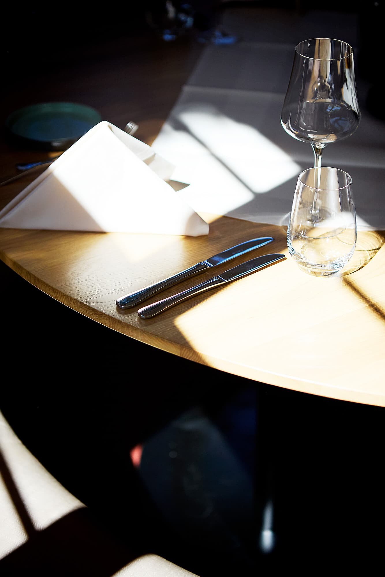 Set table with white napkin, glasses, and cutlery at B Smart Hotel Widnau.