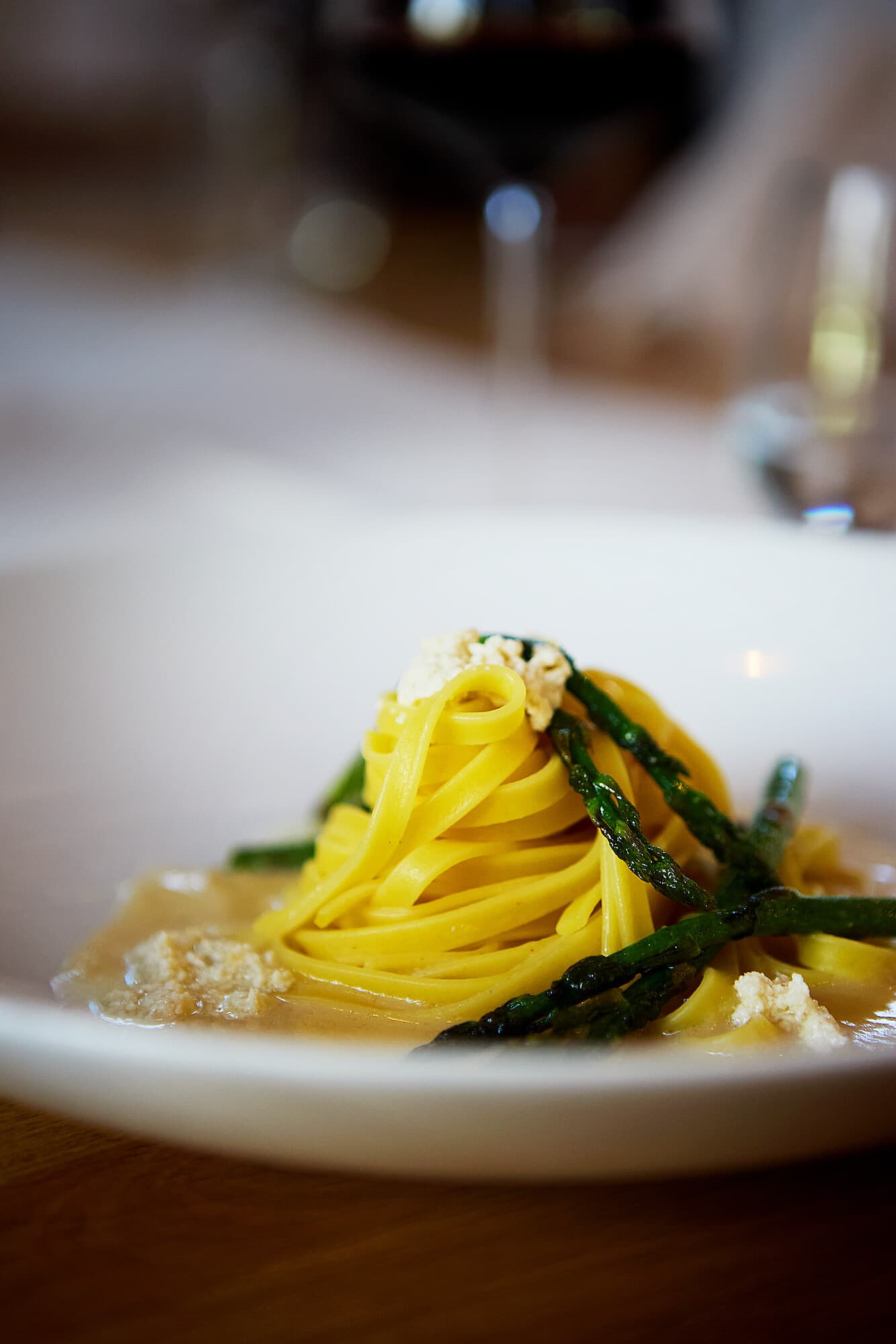 A plate with yellow tagliatelle, green asparagus, and a creamy sauce at the b smart Hotel Widnau