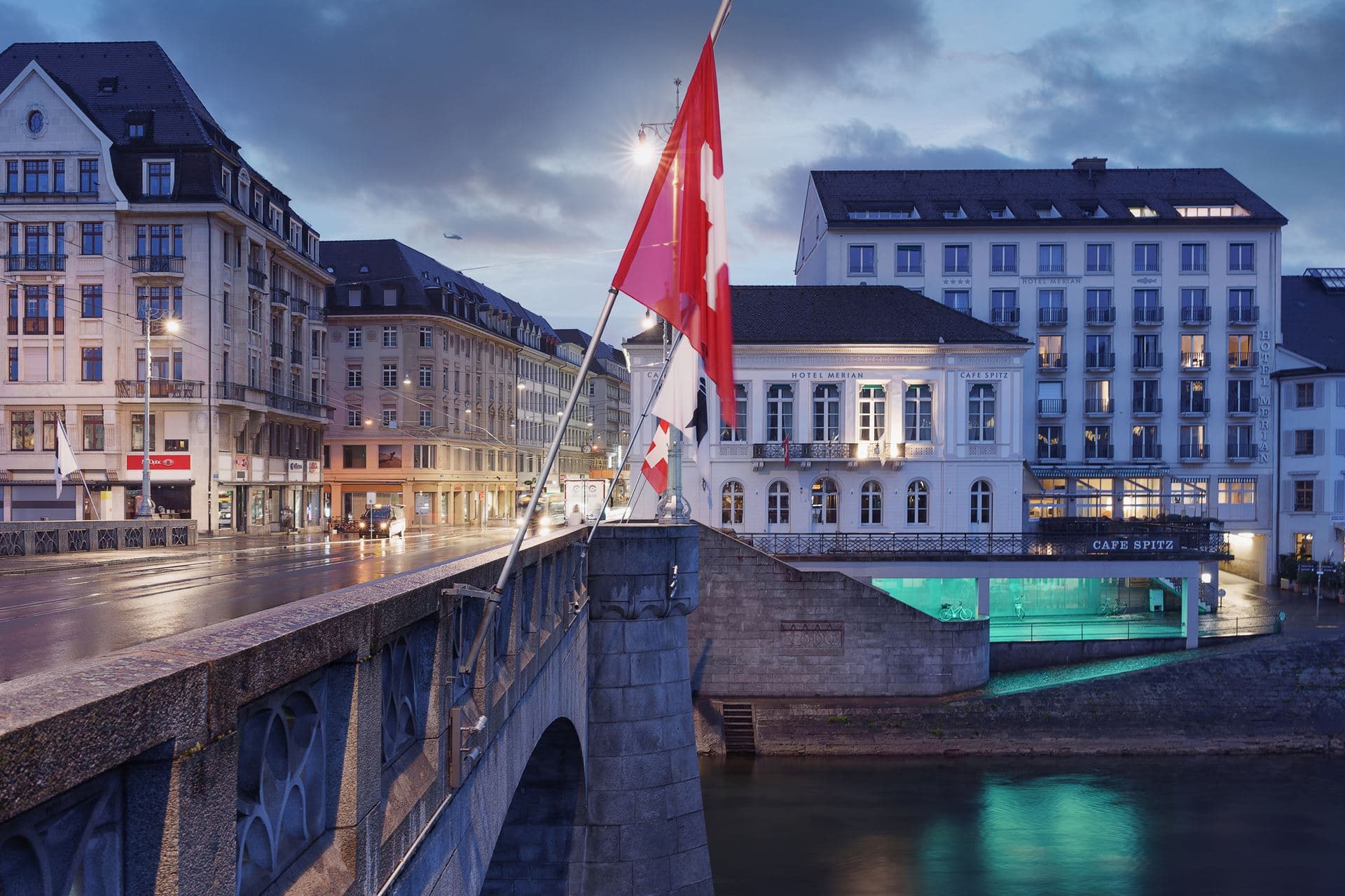 Hotel Merian am Rhein in Basel exterior view at dusk with a view of the Rhine Bridge