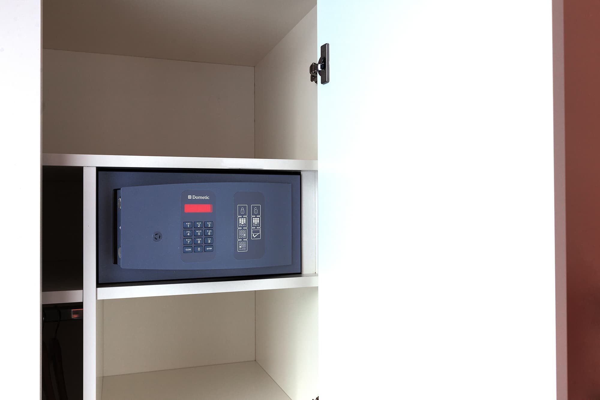 An open closet at the B Smart Motel showing a Dometic safe
