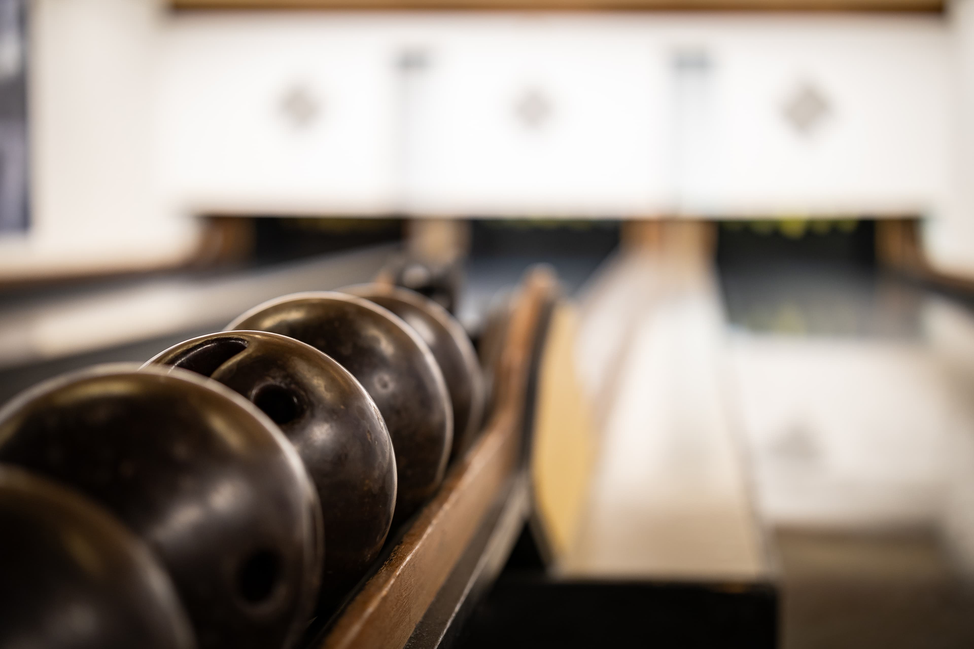 A bowling alley in the B_smart Hotel Schonenwerd with several bowling balls in a row.